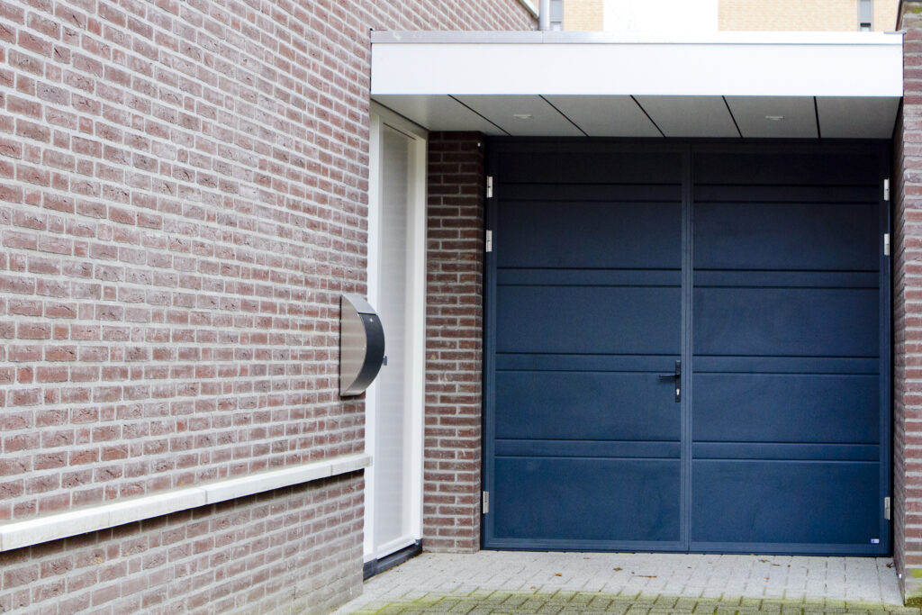 Openslaande garagedeur in moderne uitvoering met kunststof panelen – Coenen Deuren
